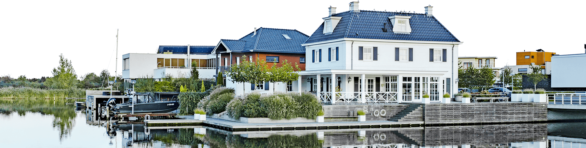 A row of houses on the side of a lake.